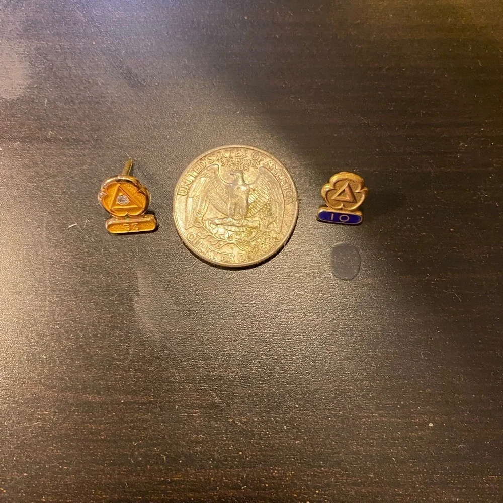 Set of 2 gold pins for city services one marked 14k on 10k one with a diamond